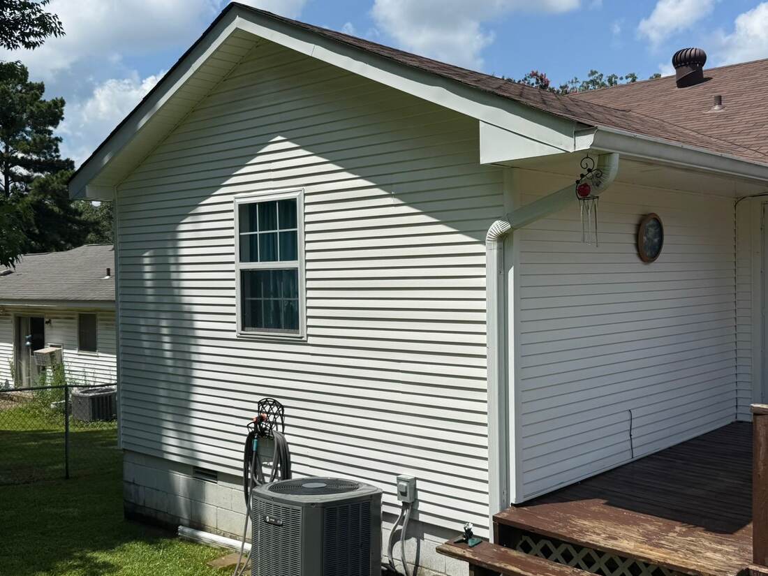 Clean white gable siding beside a deck, after cleaning